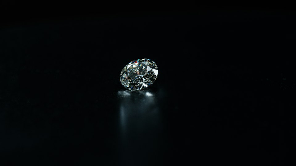 A single brilliant-cut diamond lit against black